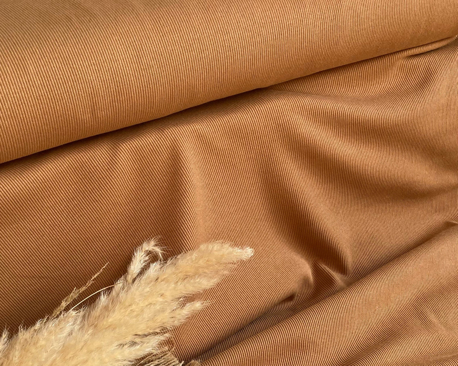 Man sieht eine Nahaufnahme des Stoffes Rippjersey in der Farbe cognac.