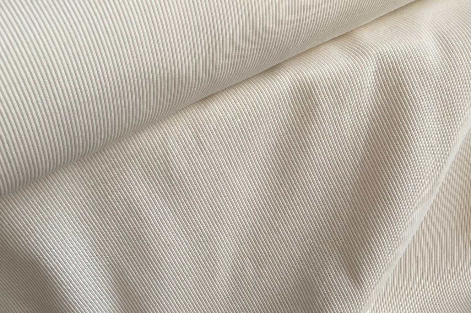Man sieht eine Nahaufnahme eines Rippjerseys in der Farbe Creme.
